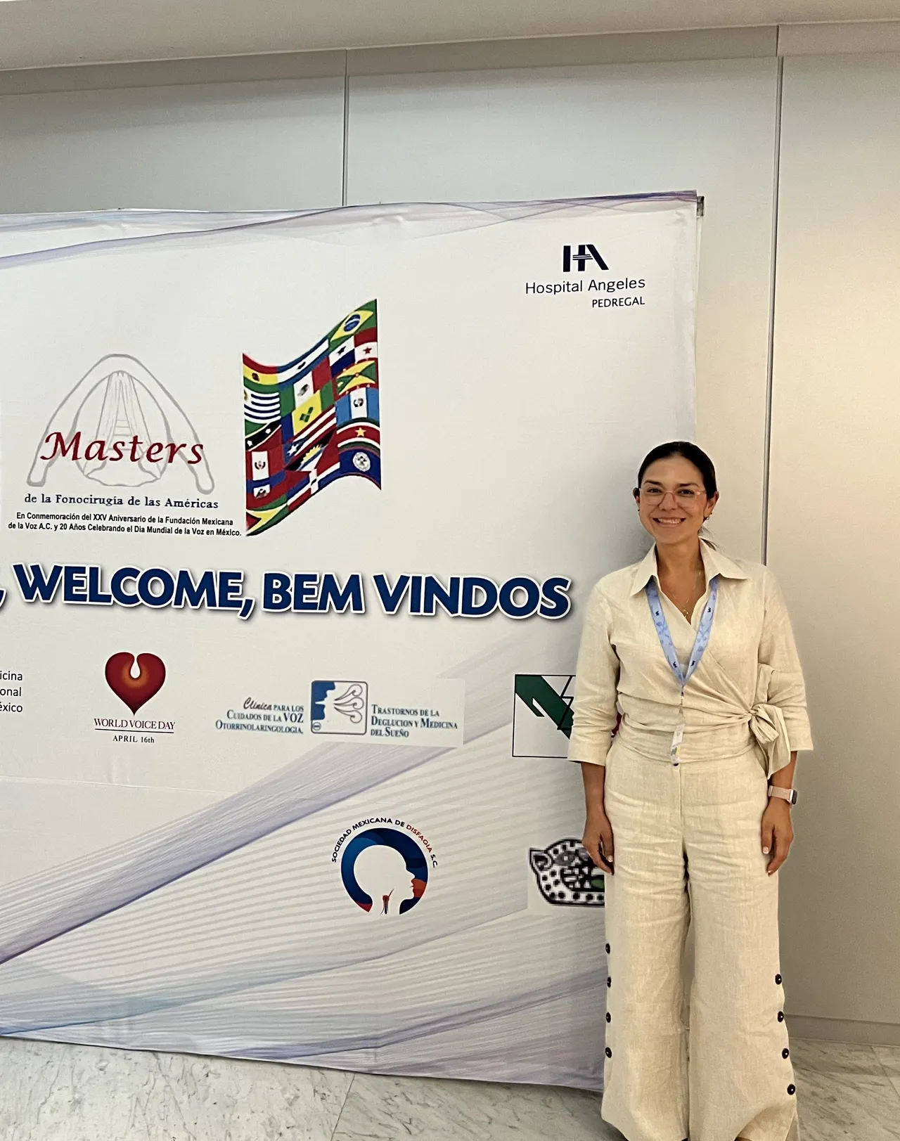 La Dra. Migzaid Díaz junto al letrero del curso Masters de la Fonocirugía de las Américas.