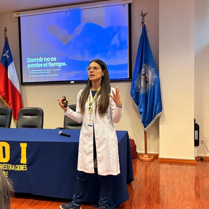 La Dra. Migzaid Díaz da una charla en la PDI; en la pantalla se lee «Dormir no es perder el tiempo».
